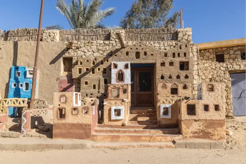 Das El-Bawity-Hotel in der Bahariya-Oase in der westlichen Wüste Ägyptens, umgeben von Palmen und Wüstenlandschaft.