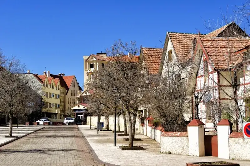 rua-tranquila-em-ifrane-com-casas-de-arquitetura-alpina-e-telhados-vermelhos-inclinados