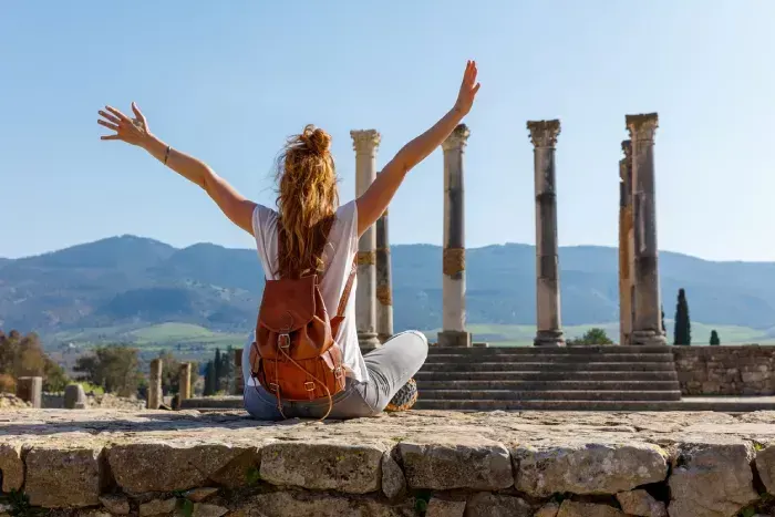 Woman tourist enjoying beautiful column and ruin of Volubilis, Meknes 