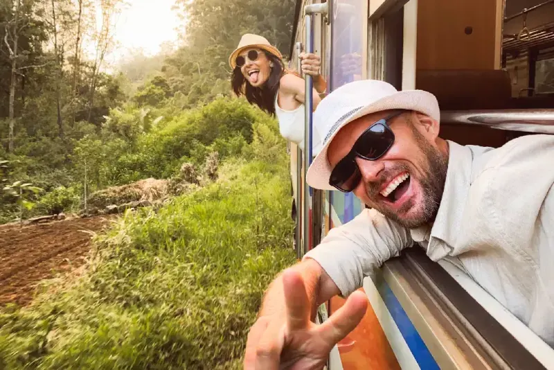 Pareja feliz de turistas viajando en tren, Sri Lanka.