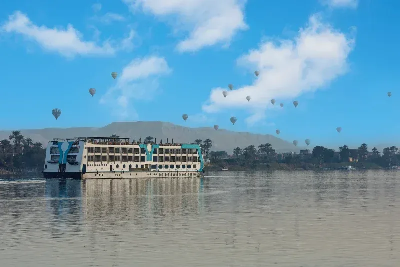 Panoramablick über den Nil auf das Westufer von Luxor mit mehreren Heißluftballons am Himmel über den historischen Landschaften Ägyptens