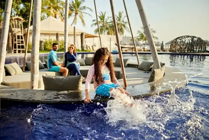 Cheerful girl enjoying the pool at a Saudi Arabian resort.