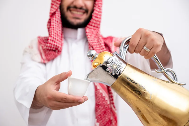 Arabian man holding arabic coffee pot, Jordanian traditional food