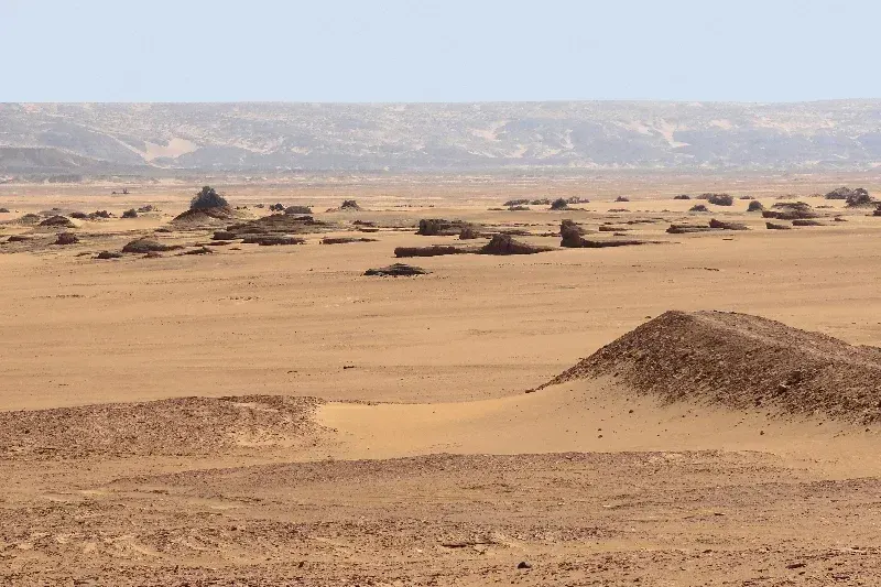 Umgebung von Qasr Dusch in der westlichen Wüste Ägyptens mit archäologischen Ruinen und karger Landschaft.