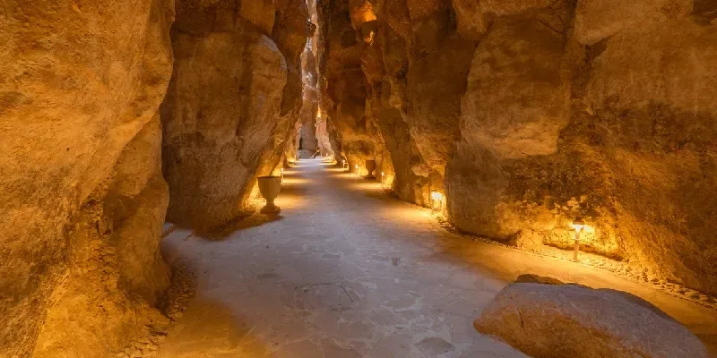 Luces cálidas iluminan un camino en el sistema de cuevas de arenisca en Al Ahsa, Arabia Saudita.