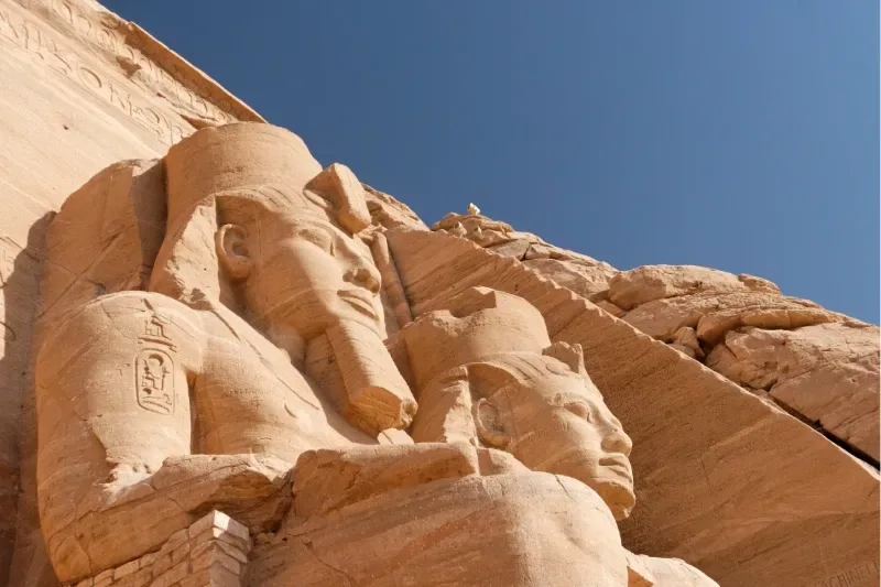 Abu Simbel, Assuan, Ägypten. 23. Februar 2022. Sonnenaufgangslicht auf den Statuen von Ptah, Amun, Ramses II. und Re im Allerheiligsten des Großen Tempels von Ramses II.