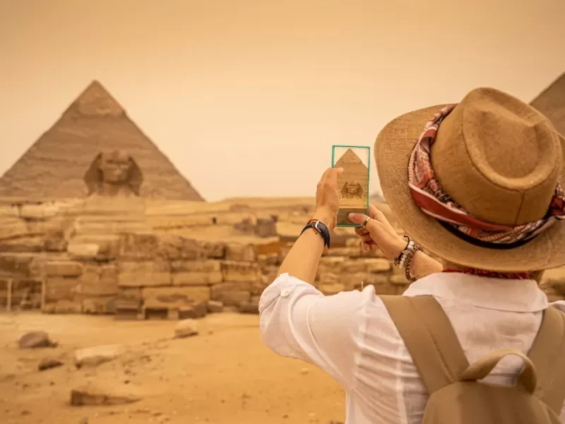 Donna che Scatta un Foto alle Piramidi, necropoli di giza