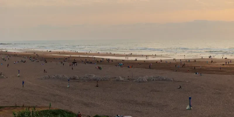 Turistas y residentes locales disfrutan de la playa de Ain Diab al atardecer en Casablanca, Marruecos.