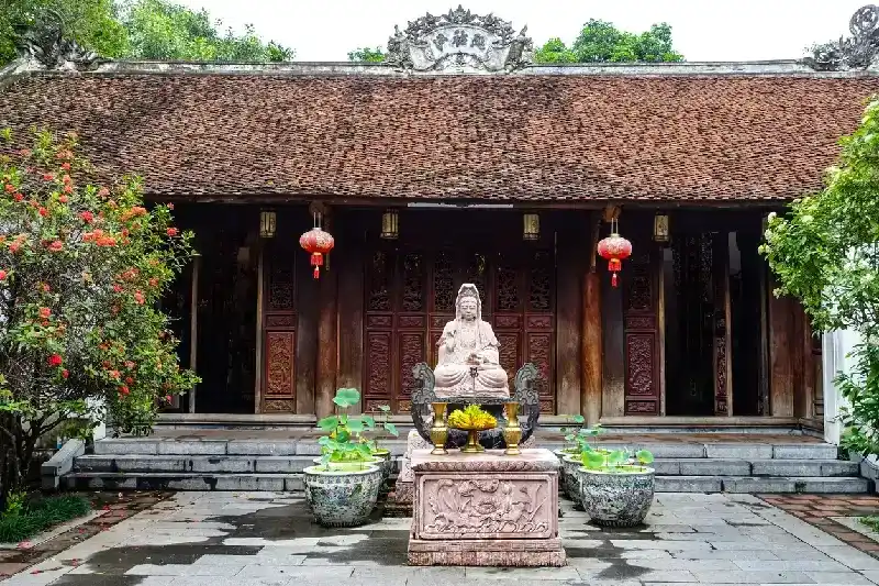 Buddhist shrine and statue in pink granite at the One Pillar Pagoda 