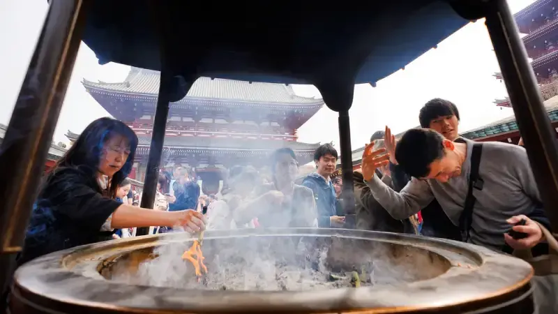  visitantes-ao-redor-do-grande-incensario-do-templo-senso-ji-banhando-se-na-fumaca-purificadora