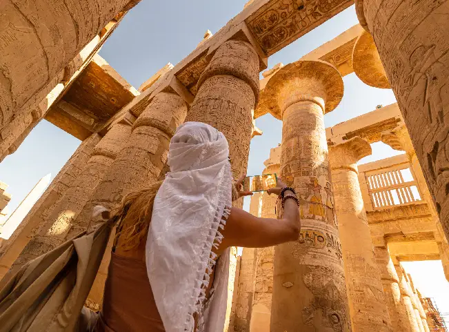 Una turista camina entre las columnas de la Gran Sala Hipóstila del templo de Karnak.