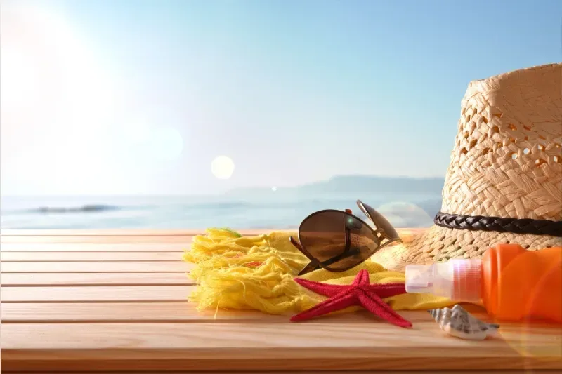 Strandartikel auf Holzdielen, im Hintergrund das Meer, Nahaufnahme