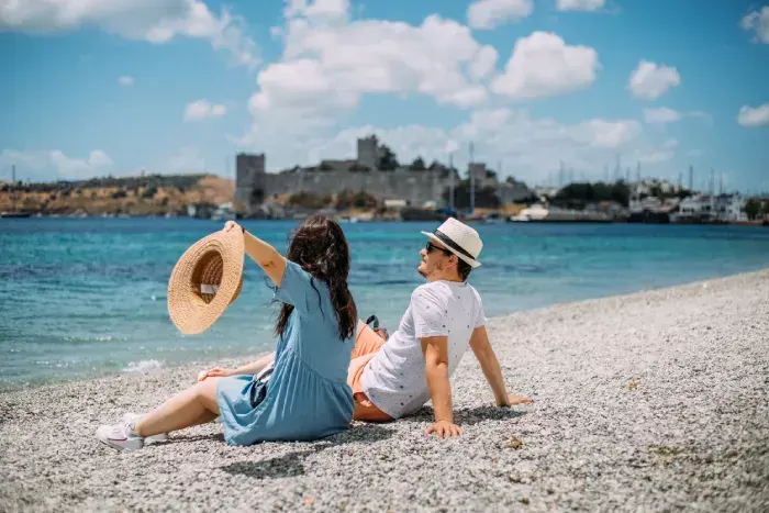 Lovely couple sitting on the beach, enjoying amazing moment, Bodrum