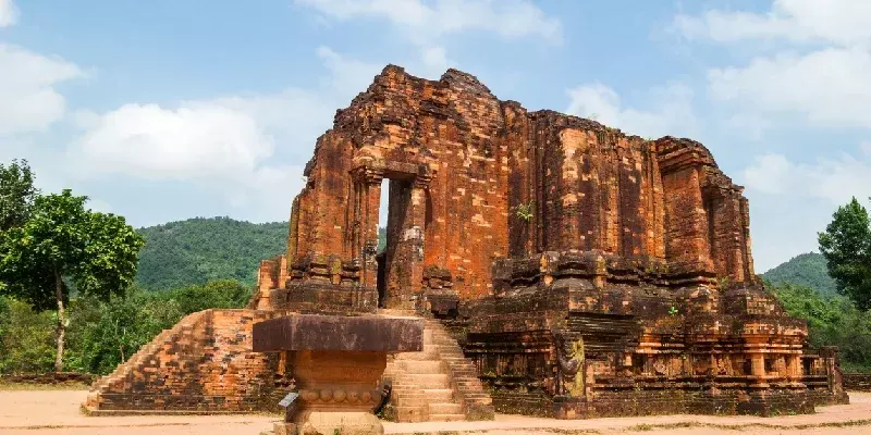 Majestuoso templo hindú antiguo con intrincados relieves, rodeado de exuberante vegetación. My Son, Vietnam.