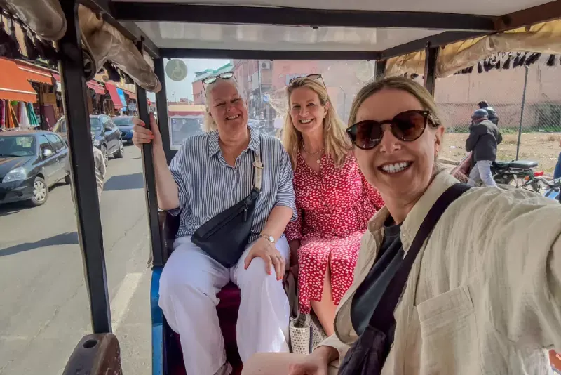 Amigas solas tomando selfie en un tuk-tuk por las calles de Marrakech. 