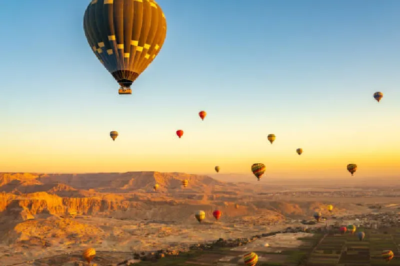 Heißluftballons bei Sonnenaufgang über dem Tal der Könige in Luxor, Ägypten