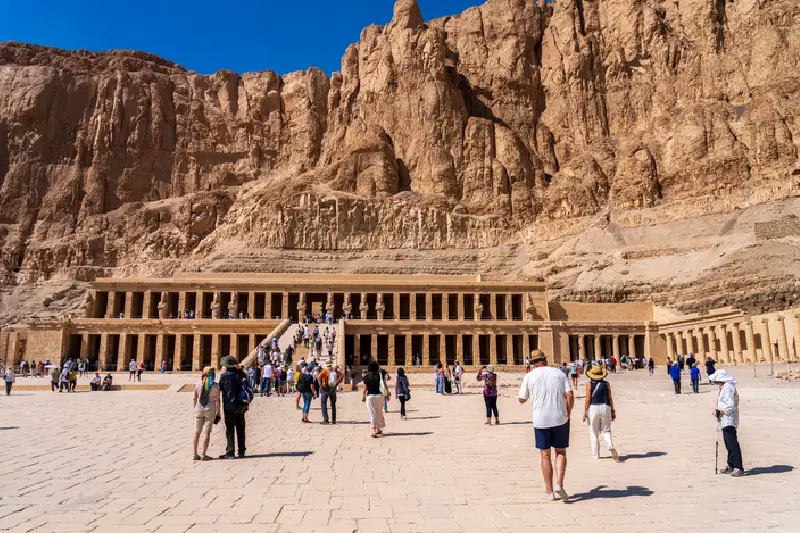 Los turistas caminan hacia el templo funerario de Hatshepsut.