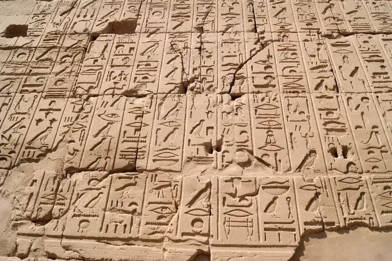 Ägyptische Tempelwand mit eingemeißelten Hieroglyphen in senkrechten Schriftkolumnen