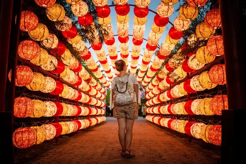 Tourist walking through beautiful arch of lights in Hoi An