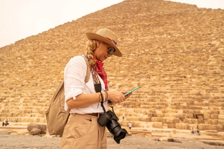 A traveler using phone at Pyramids 