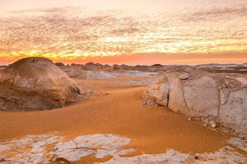 Sonnenaufgang in der Weißen Wüste nahe der Bahariya-Oase in Ägypten mit hellen Kalksteinformationen im Morgenlicht.