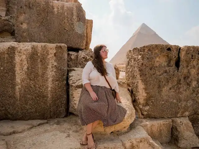 Guide égyptologue expliquant les hiéroglyphes à un groupe de voyageurs dans un temple