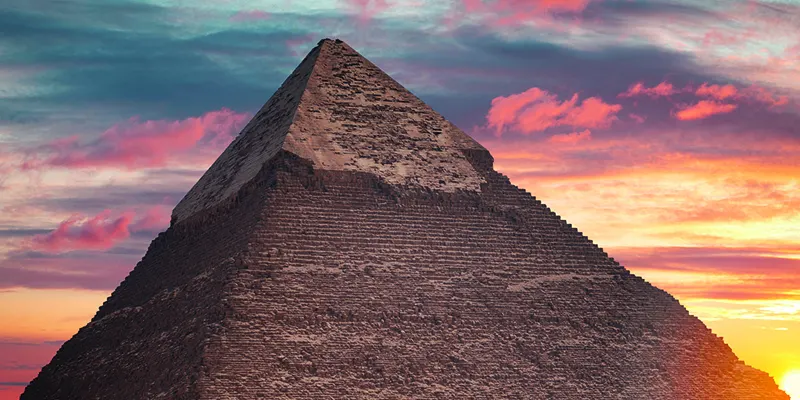 Khafre Pyramid at sunset on the Giza Plateau, Egypt, with a golden sky highlighting ancient Egyptian architecture