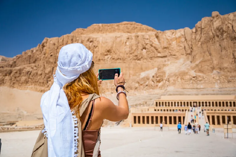 Mujer tomando una foto del templo de la reina Hatshepsut, Luxor, Egipto.