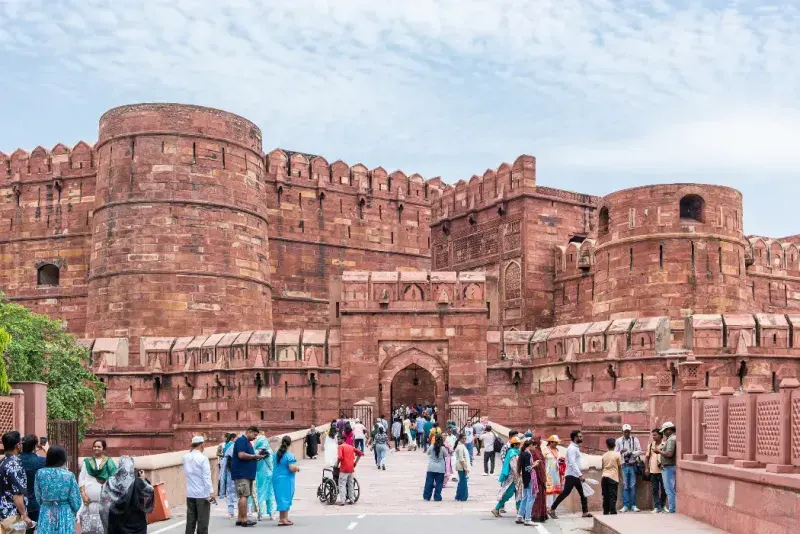 Personas de pie en la entrada del Fuerte Rojo de Agra, en la ciudad de Agra, India.
