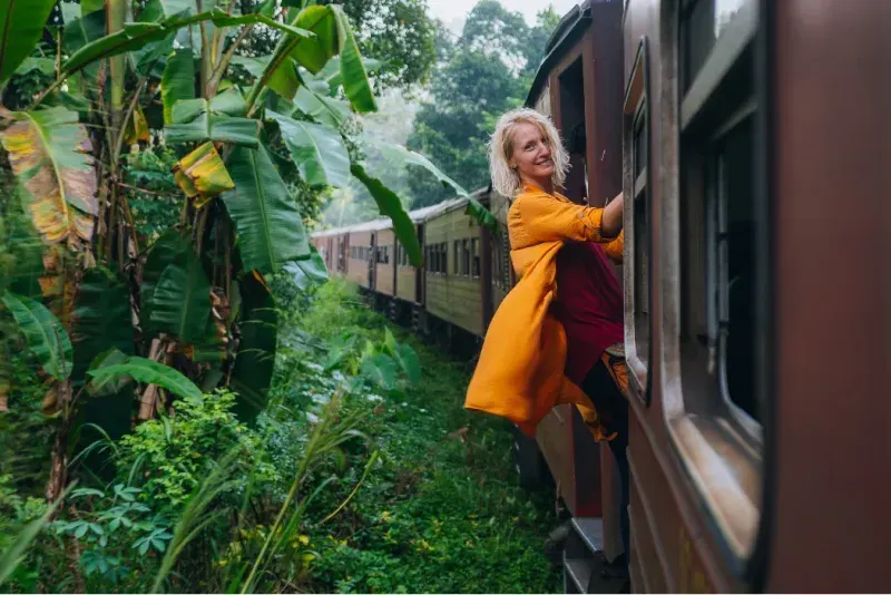 Una turista disfruta de un famoso viaje panorámico en tren a través de Sri Lanka.