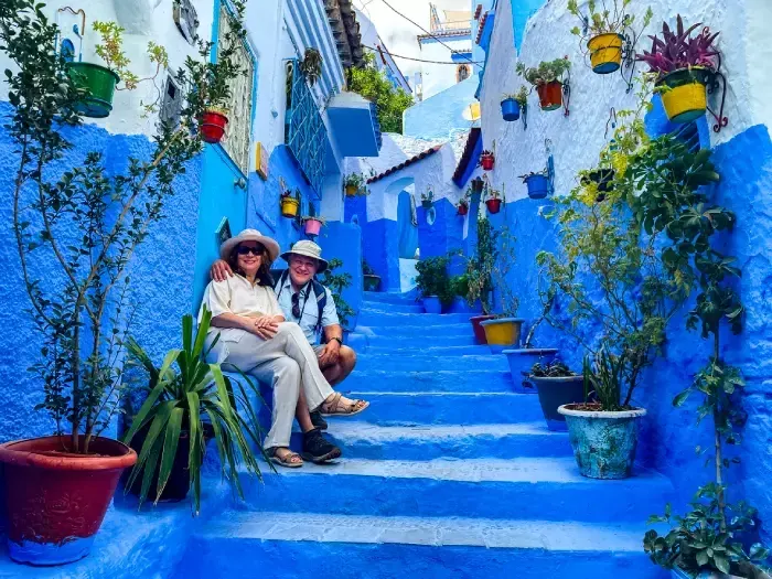 Old couple posing on stairway in Chefchaouen, Morocco