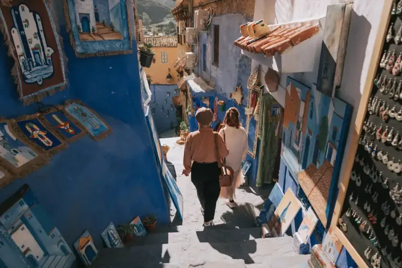  2 Asian Chinese female tourist shopping in souk market in Chefchaouen
