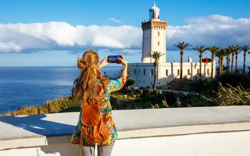 Tourism in Morocco-woman tourist taking photography of cap spartel, tanger