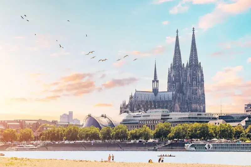 Malerischer Blick auf das Rheinufer mit der Kölner Skyline, fliegenden Vögeln und dem berühmten Kölner Dom
