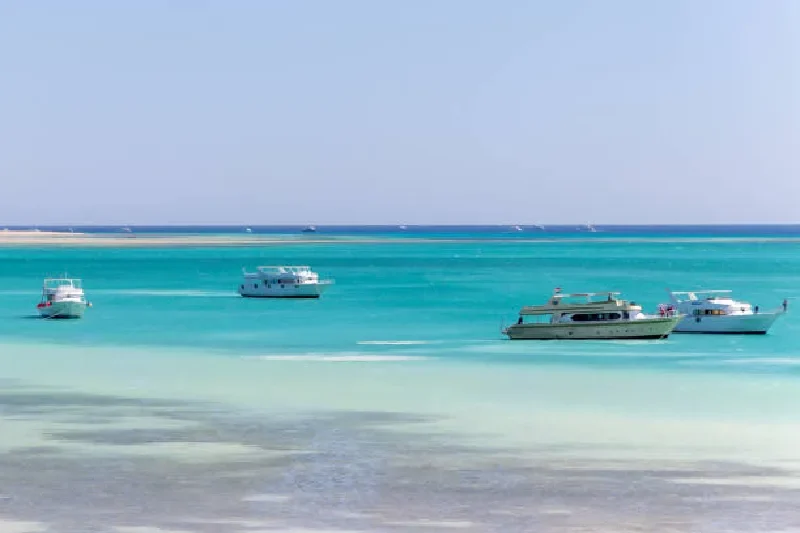 Orange Bay Strand mit kristallklarem, azurblauem Wasser und Booten im Meer