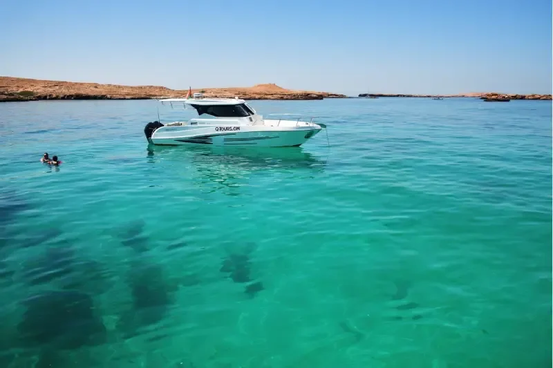 Isole Daymaniyat, Oman: barca bianca ormeggiata nel Golfo dell'Oman, una delle migliori destinazioni per snorkeling e immersioni.