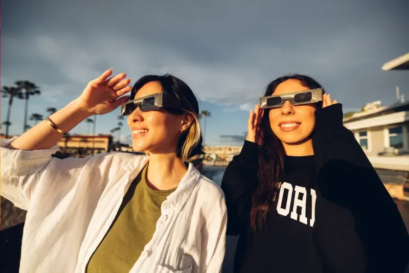 Two friends have fun together during a solar eclipse event.