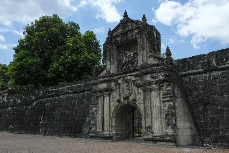 stone-entrance-gate-of-fort-santiago-featuring-carved-spanish-coat-of-arms-and-relief-sculpture-surrounded-by-ancient-stone-walls