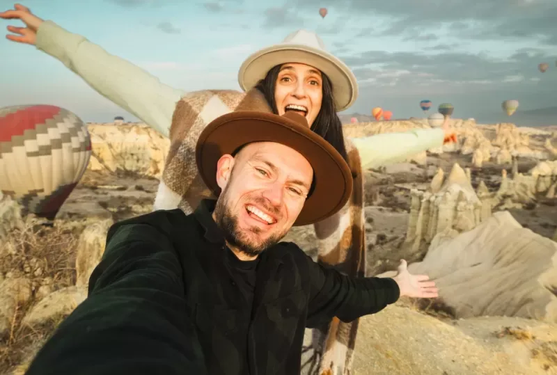 pareja-de-turistas-divirtiendose-viendo-globos-aerostaticos-de-cerca