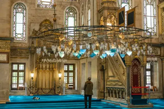 A person standing in Eyup Sultan Mosque