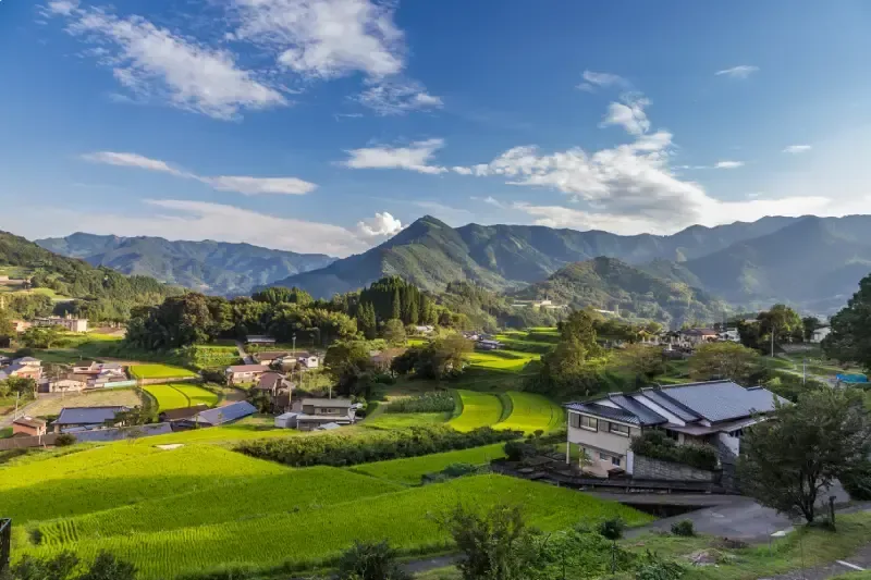 vista-de-vila-agricola-com-arrozais-verdes-casas-tradicionais-e-montanhas-ao-fundo-takachiho-miyazaki-ilha-de-kyushu-japao