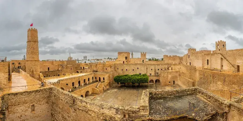 Patios interiores y murallas del Ribat de Monastir en panorama bajo cielos nublados