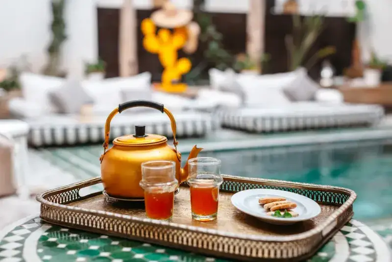 Moroccan mint tea served by the poolside in a peaceful courtyard riad