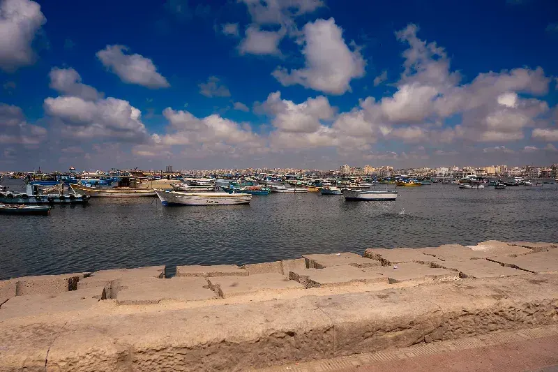 Fischerboote treiben nahe der Strandpromenade von Alexandria am Mittelmeer in Ägypten