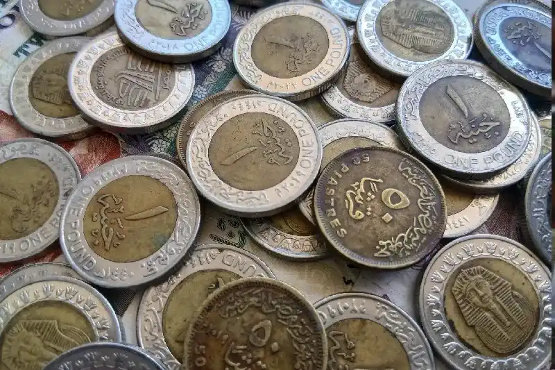 Nahaufnahme von ägyptischen Ein-Pfund-Münzen, die auf Banknoten liegen und die nationale Währung, Finanzen, Sparen sowie alltägliche Bargeldtransaktionen in Ägypten darstellen.