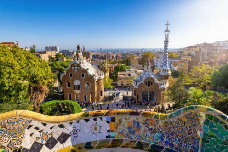 Bunte Mosaike, geschwungene Architektur und Panorama von Barcelona im Park Güell, Spanien