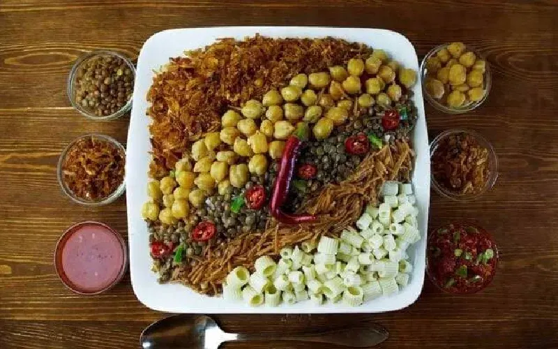 Plat traditionnel de koshari égyptien servi avec du thé à la menthe