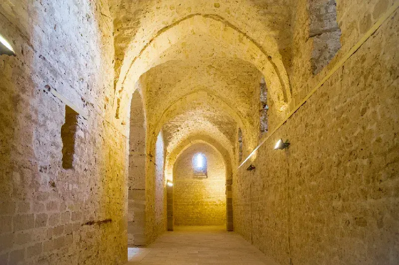 Ein Fenster im Innenbereich der Zitadelle von Qaitbay in Alexandria, Ägypten, mit Blick auf die historische Steinarchitektur der Festung.