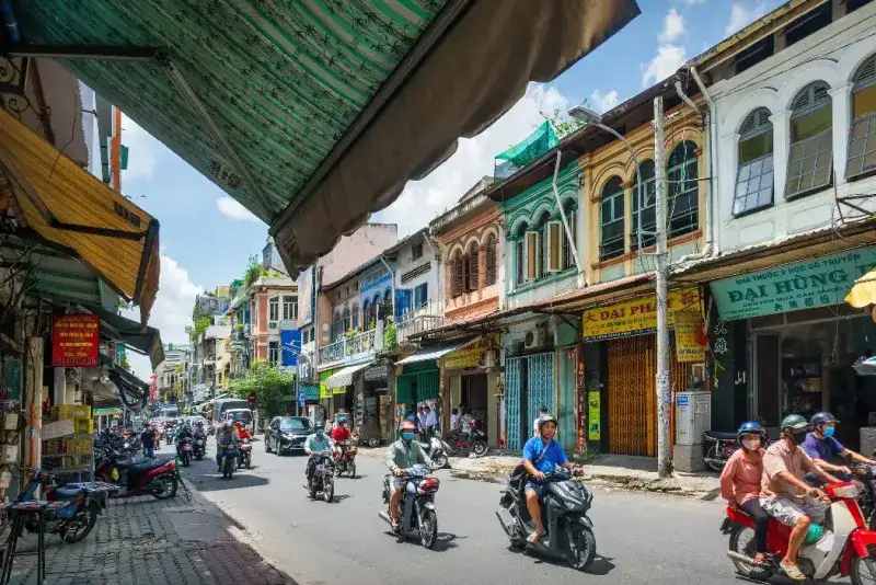 Conductores de scooters circulan por el casco antiguo de Ciudad Ho Chi Minh, en el barrio de Cholon, Vietnam.