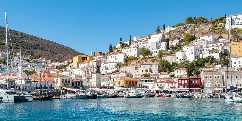 vista-panoramica-de-edificios-en-la-colina-que-rodean-el-puerto-con-barcos-y-embarcaciones-atracadas-en-la-isla-de-hydra-grecia
